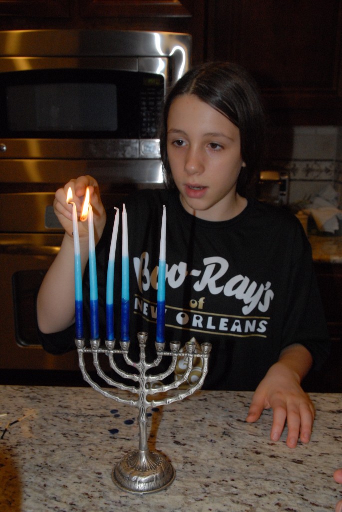 Grace lights candles for Hanukkah.